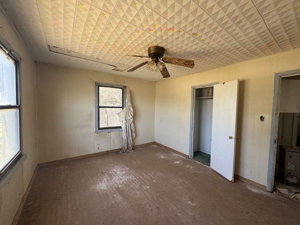 200 West 2nd Street Plainview, TX 79072 - Photo 5 of 6 an empty room with windows and ceiling fan