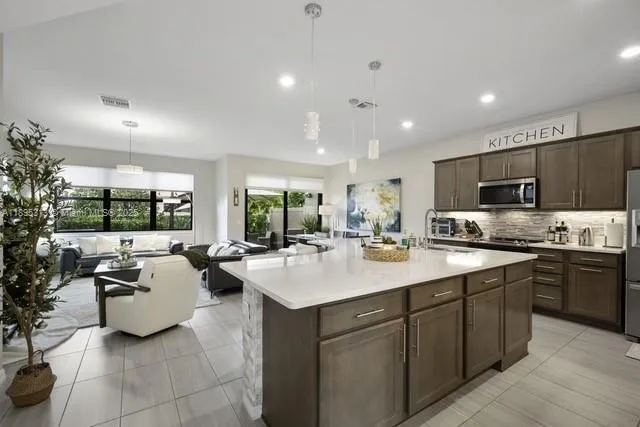a kitchen with stainless steel appliances granite countertop a sink a stove and a refrigerator