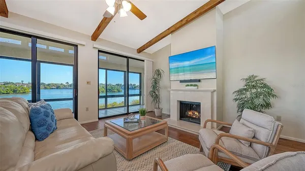 a living room with furniture a fireplace and a floor to ceiling window
