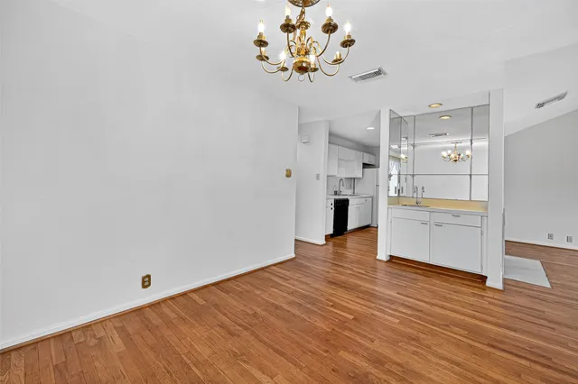 a view of a kitchen with wooden floor and a refrigerator