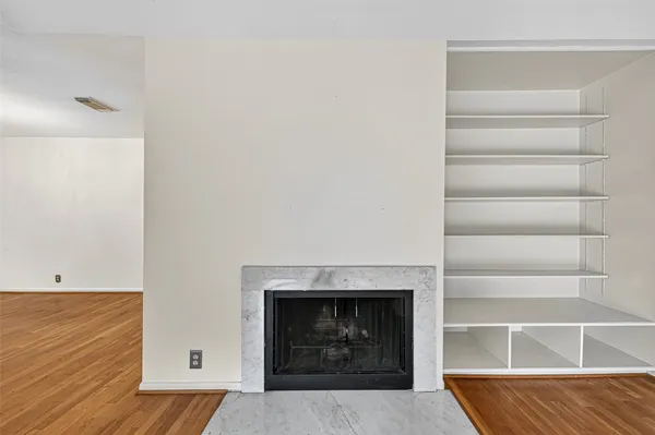 a living room with a fireplace and a ceiling fan