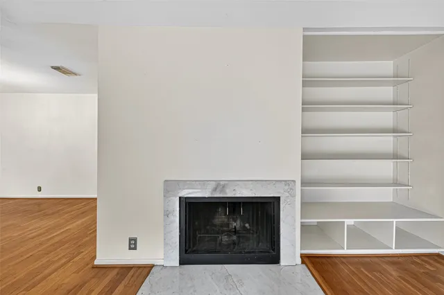 a living room with a fireplace and a ceiling fan