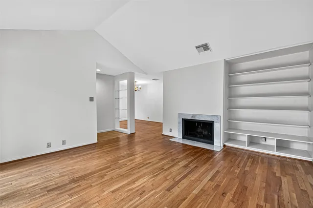 wooden floor fireplace and natural light in room