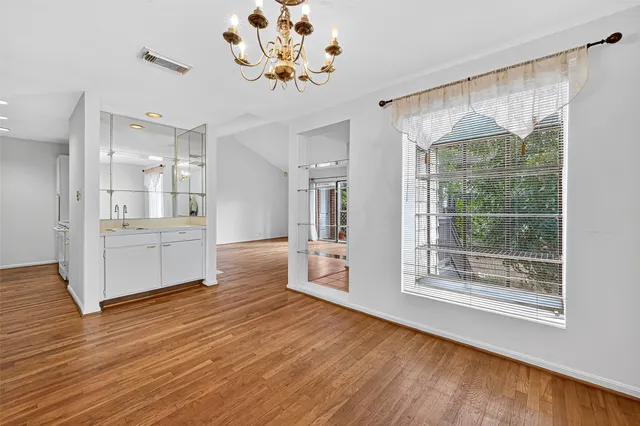 a view of a big room with wooden floor and windows
