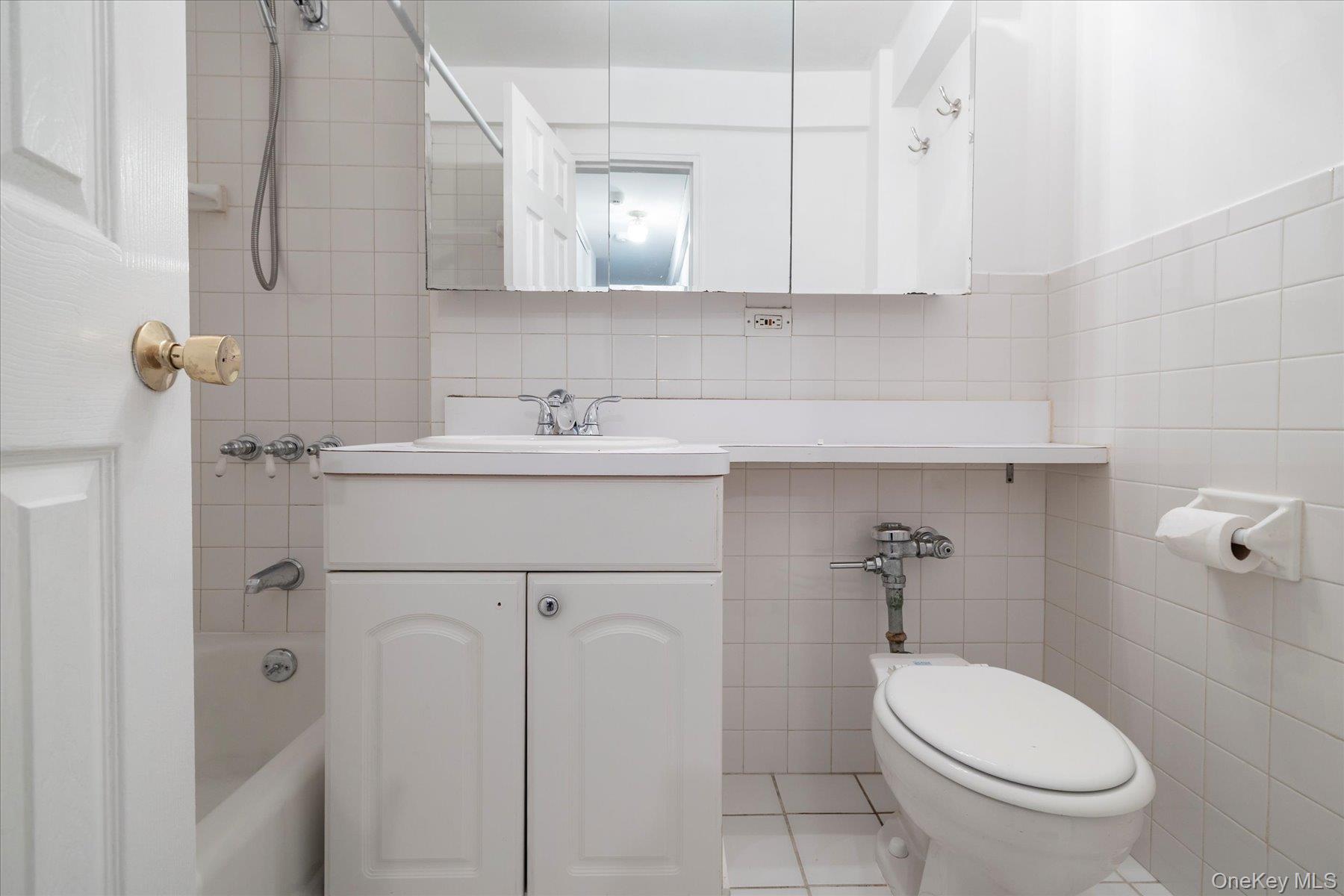 420 Shore Road, Unit 1F Long Beach, NY 11561 - Photo 16 of 32 a bathroom with a sink a toilet and mirror