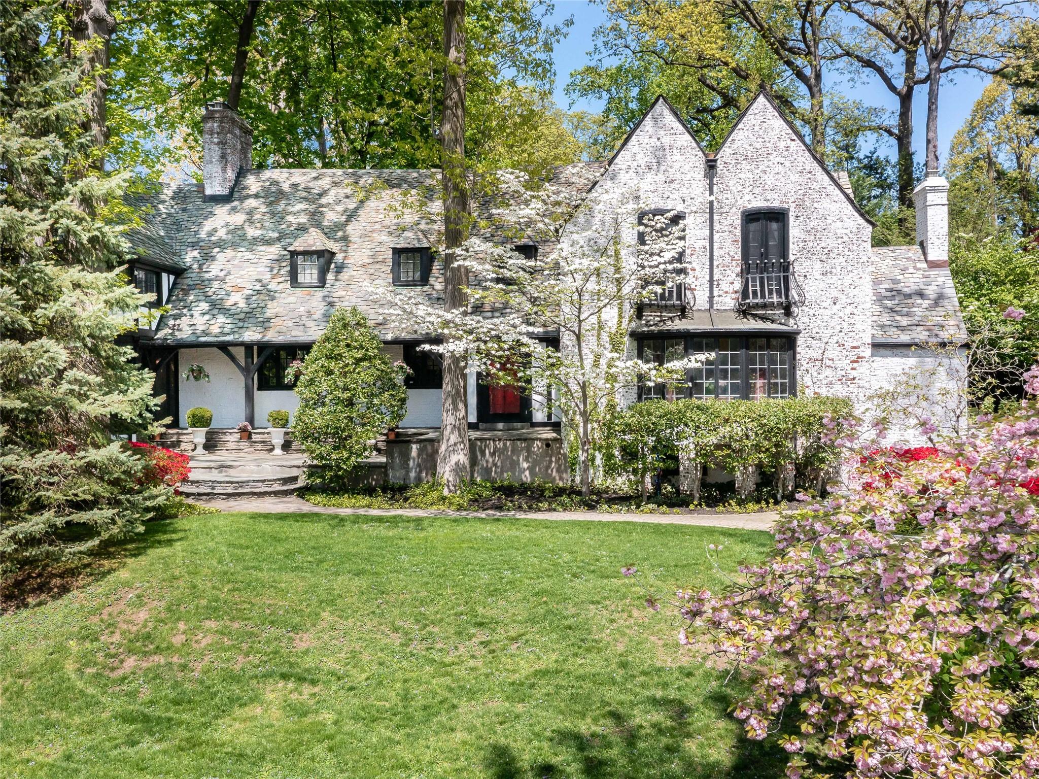 a view of a house with a big yard plants and large trees