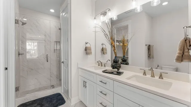 a bathroom with a double vanity sink mirror and shower