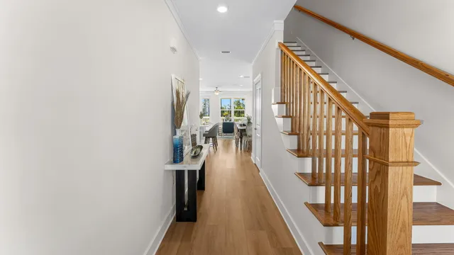 a view of a hallway with wooden floor and staircase