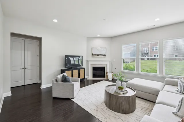 a living room with furniture a fireplace and a window