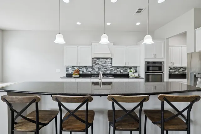 a kitchen with stainless steel appliances granite countertop a stove a sink and a refrigerator