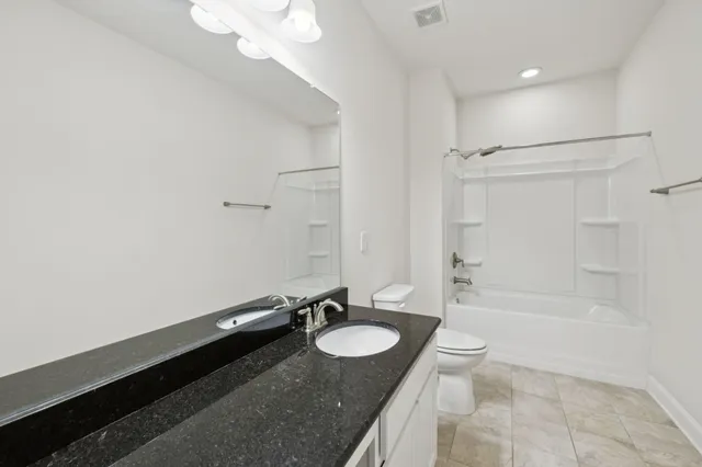 a bathroom with a double vanity sink a mirror a bathtub and a shower