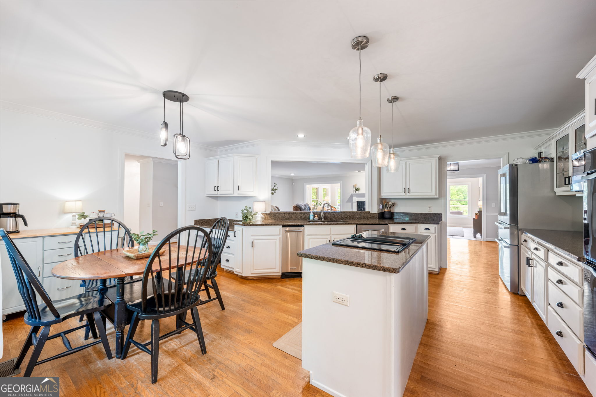 570 Martin Mill Road Moreland, GA 30259 - Photo 15 of 68 a kitchen with stainless steel appliances a dining table chairs stove and white cabinets