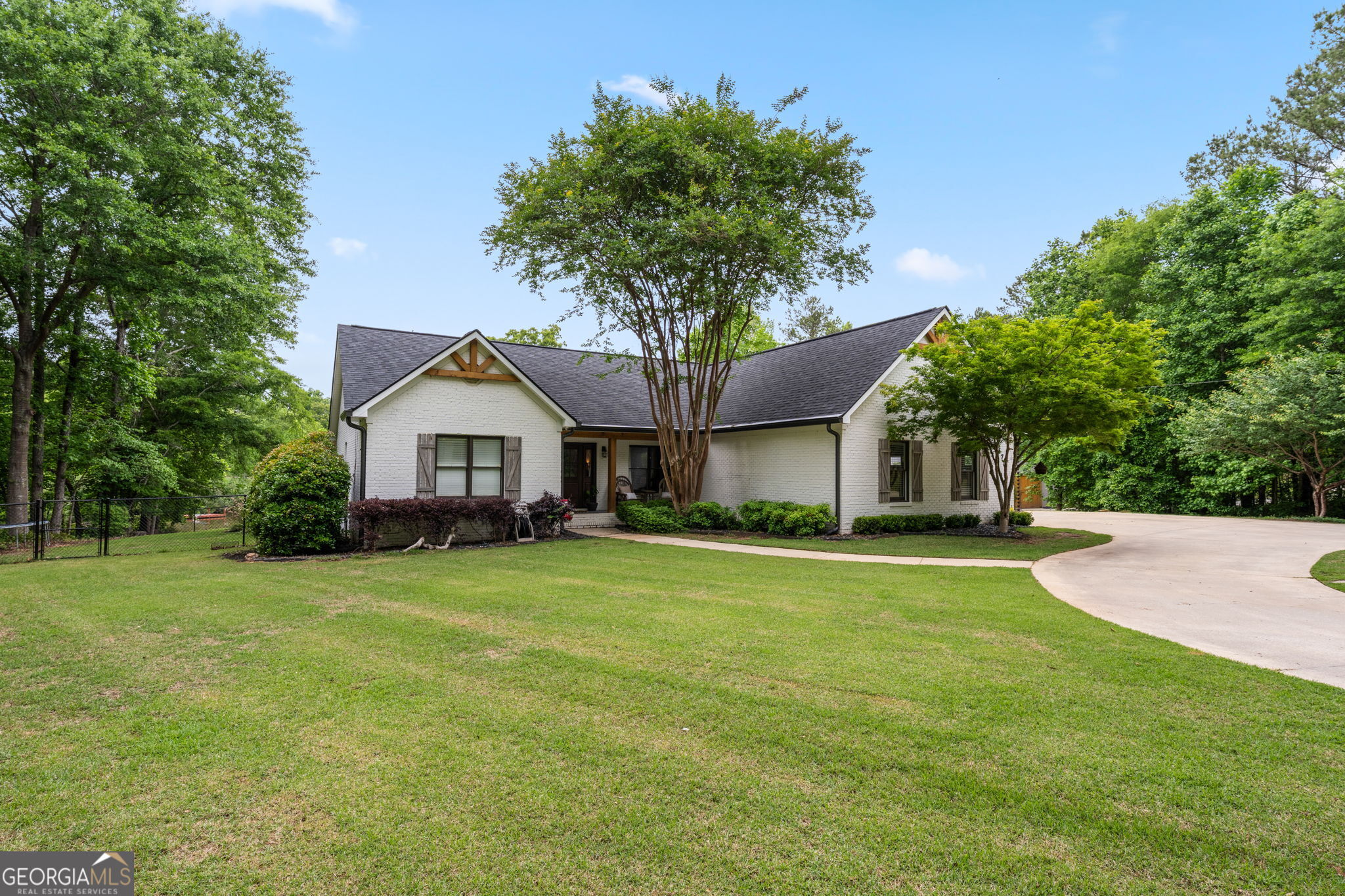 570 Martin Mill Road Moreland, GA 30259 - Photo 2 of 68 a front view of a house with a garden and trees