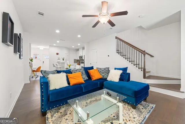 a living room with furniture ceiling fan and a rug