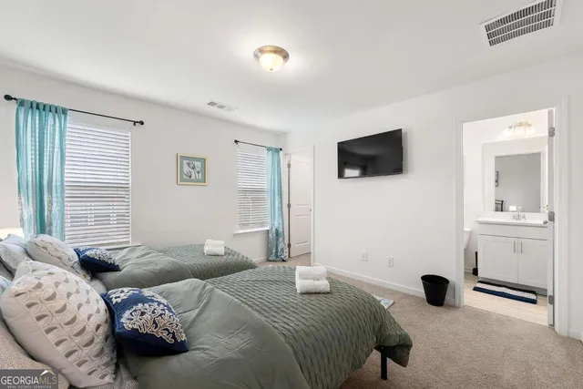 a bedroom with two bed and a flat screen tv