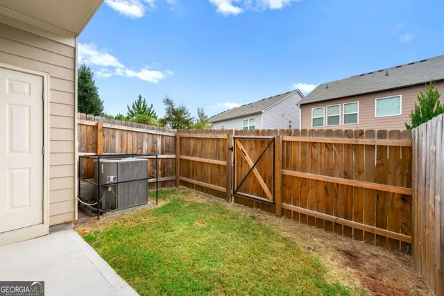 a view of a backyard with wooden fence