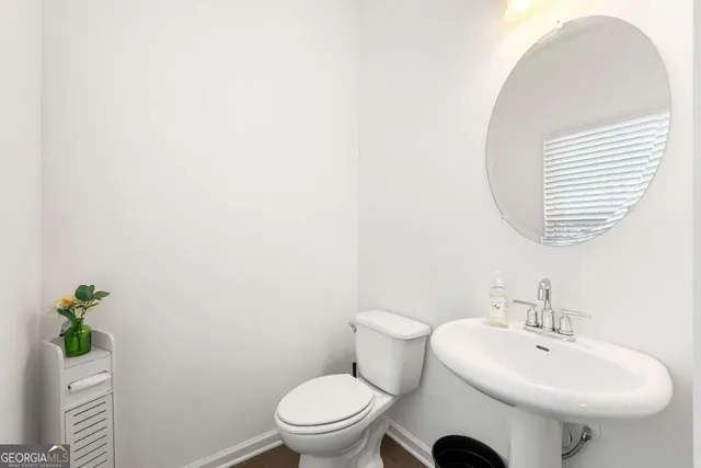 a bathroom with a sink toilet and a mirror