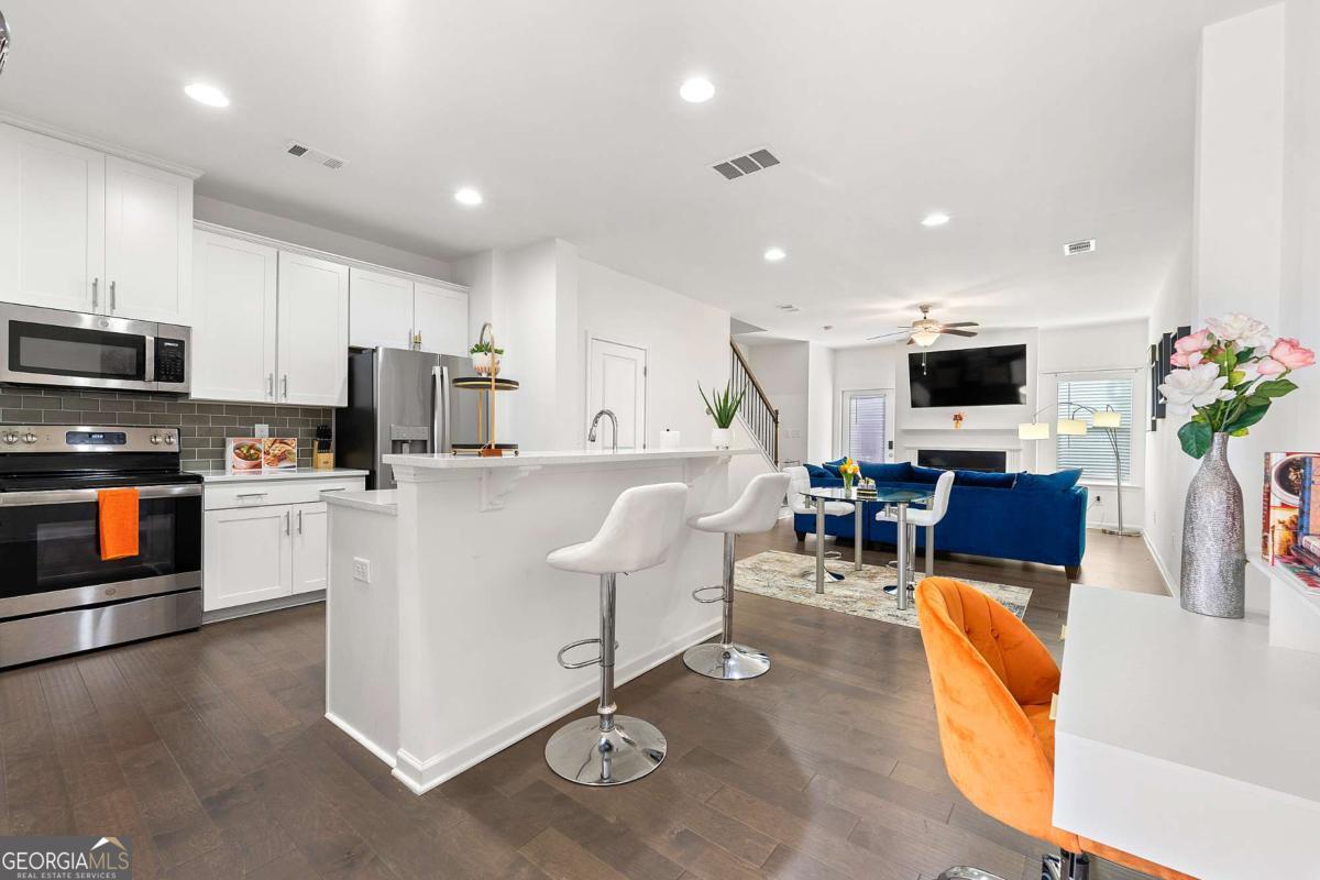 849 Crestwell Circle Atlanta, GA 30331 - Photo 5 of 21 a living room with stainless steel appliances furniture a flat screen tv and a kitchen view
