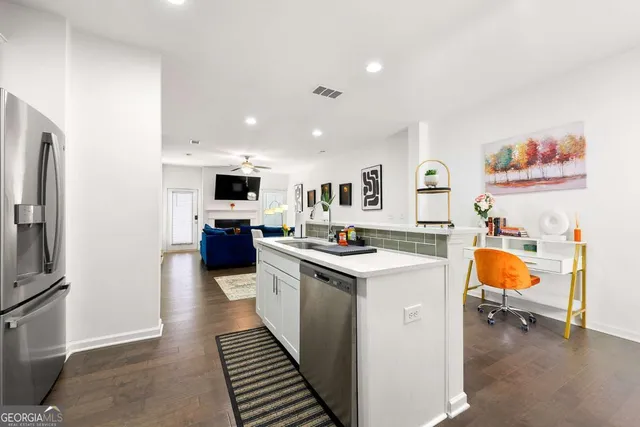 a kitchen with a sink a counter top space stainless steel appliances and cabinets