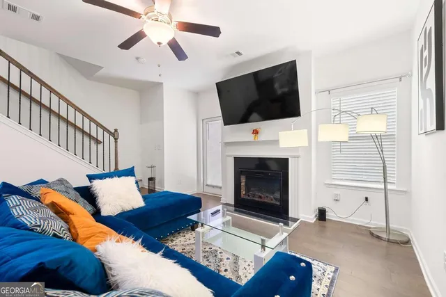 a living room with furniture a flat screen tv and a fireplace