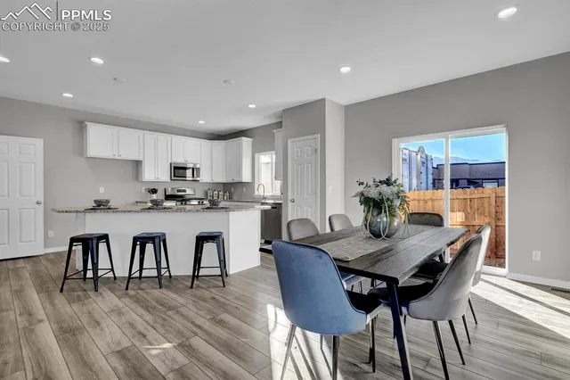 a view of a dining room with furniture wooden floor and a kitchen view