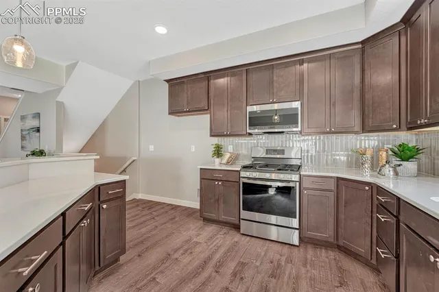 a kitchen with granite countertop wooden cabinets and stainless steel appliances