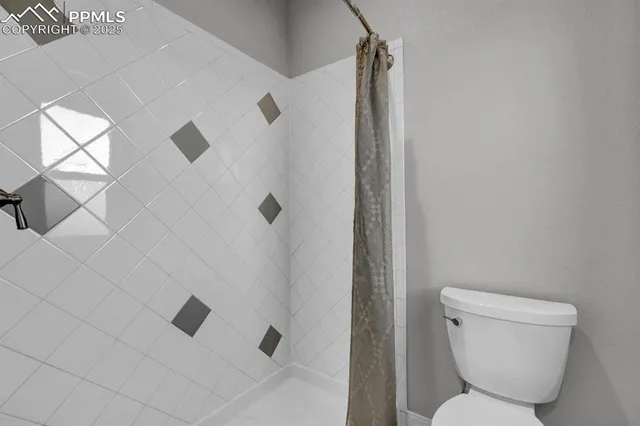 a bathroom with a toilet and shower