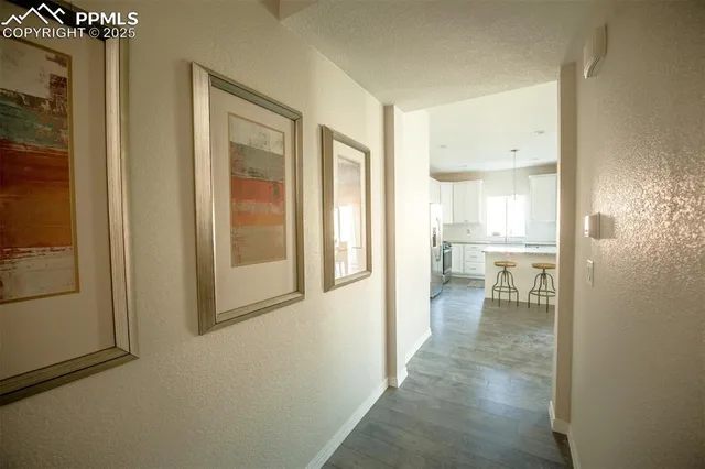 a view of a hallway with a livingroom and a bathroom with sink