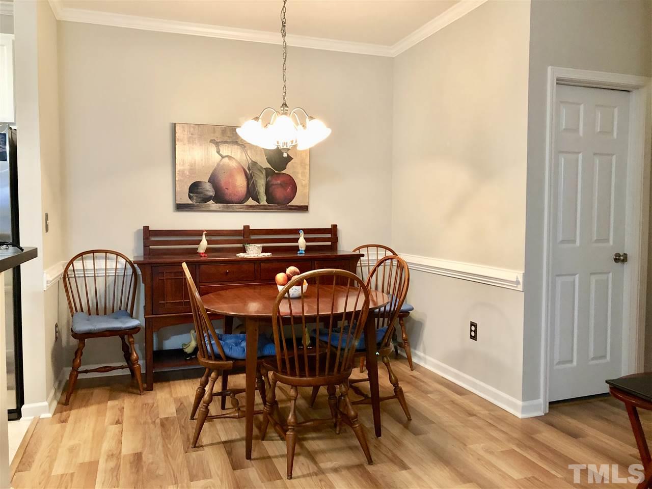 212 West Savannah Ridge Road, Unit 212 Holly Springs, NC 27540 - Photo 7 of 21 a view of a dining room with furniture wooden floor and chandelier