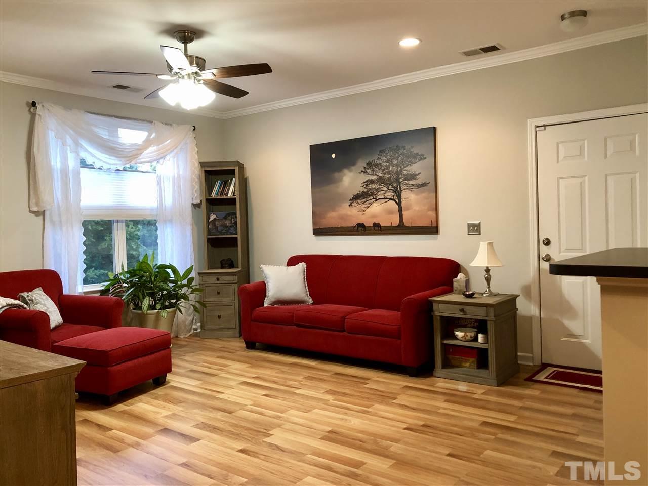 212 West Savannah Ridge Road, Unit 212 Holly Springs, NC 27540 - Photo 9 of 21 a living room with furniture a chandelier and a flat screen tv