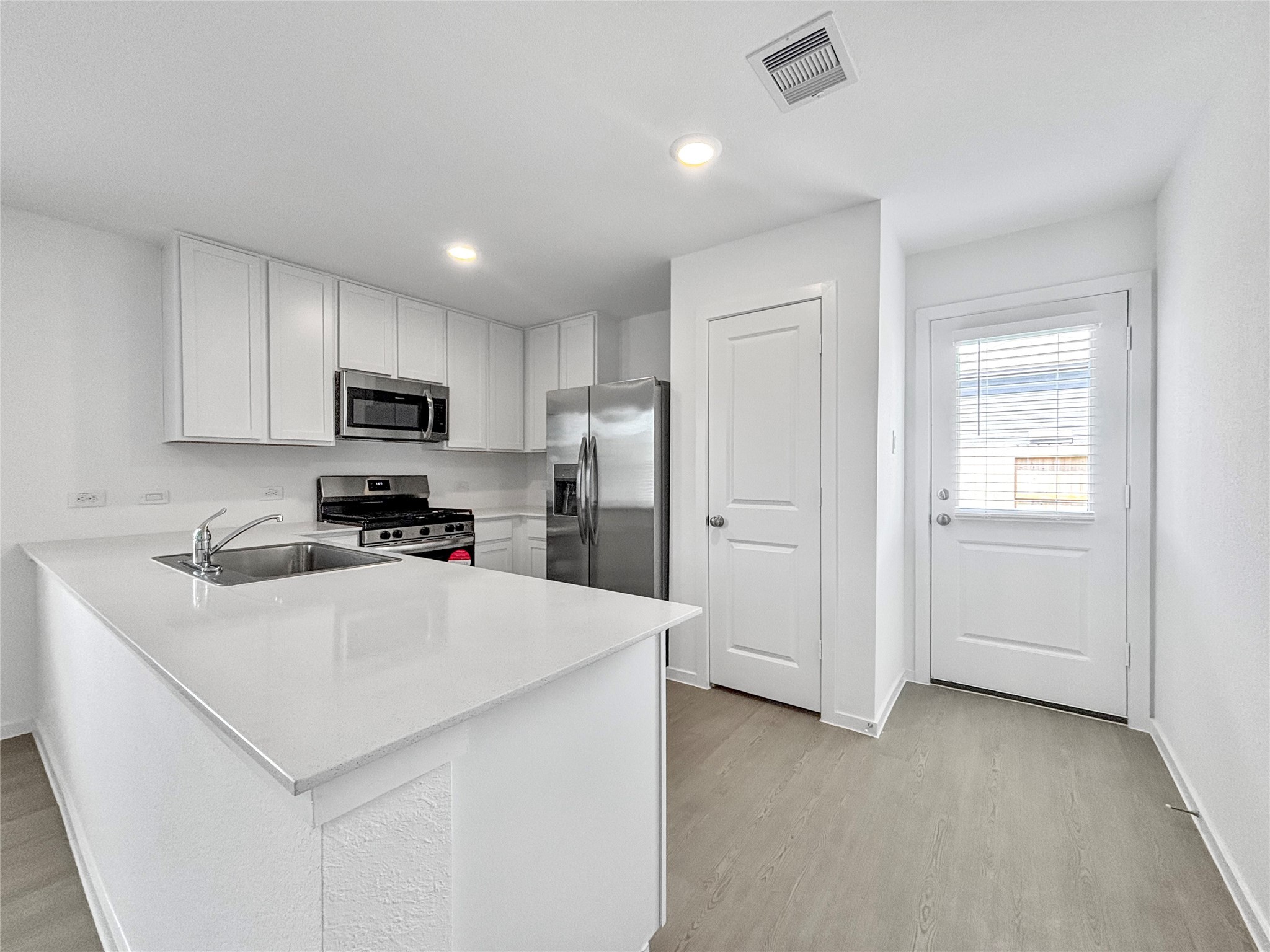 6022 Standpiper Loop Baytown, TX 77521 - Photo 4 of 16 a kitchen with a refrigerator a microwave a sink and cabinets