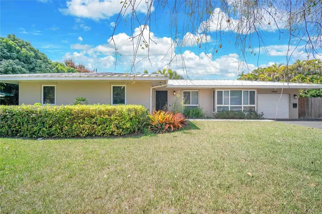 a view of a house with a yard and potted plants