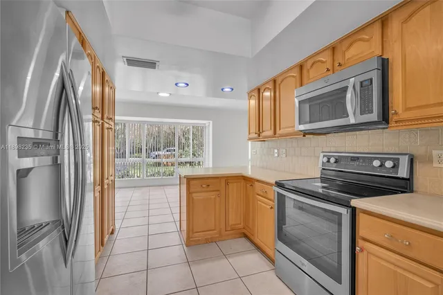 a kitchen with stainless steel appliances granite countertop a refrigerator and a stove top oven