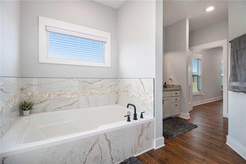 111 Possum Trot Road Barnesville, GA 30204 - Photo 21 of 54 a bathroom with bathtub and a wooden floor