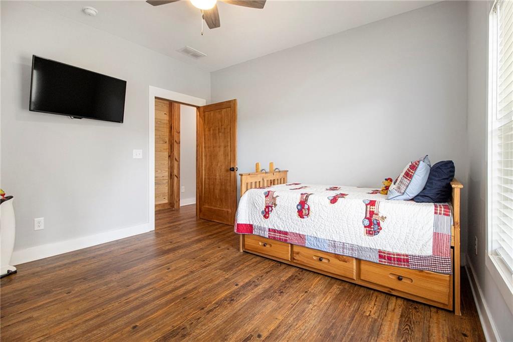 111 Possum Trot Road Barnesville, GA 30204 - Photo 28 of 54 a white bed sitting in a bedroom next to a flat tv screen and a wooden floor