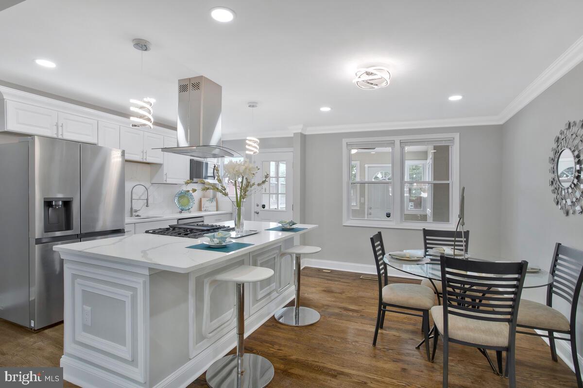 4243 Flowerton Road Baltimore, MD 21229 - Photo 2 of 35 a kitchen with stainless steel appliances granite countertop a table chairs and a refrigerator