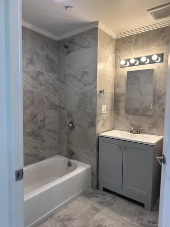 a bathroom with a tub a sink and mirror