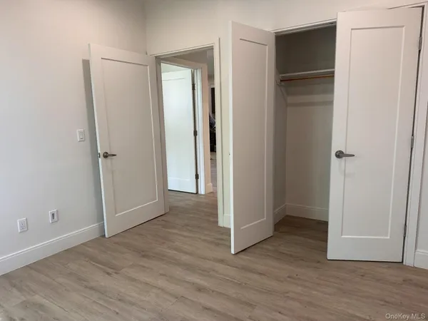 an empty room with wooden floor and closet