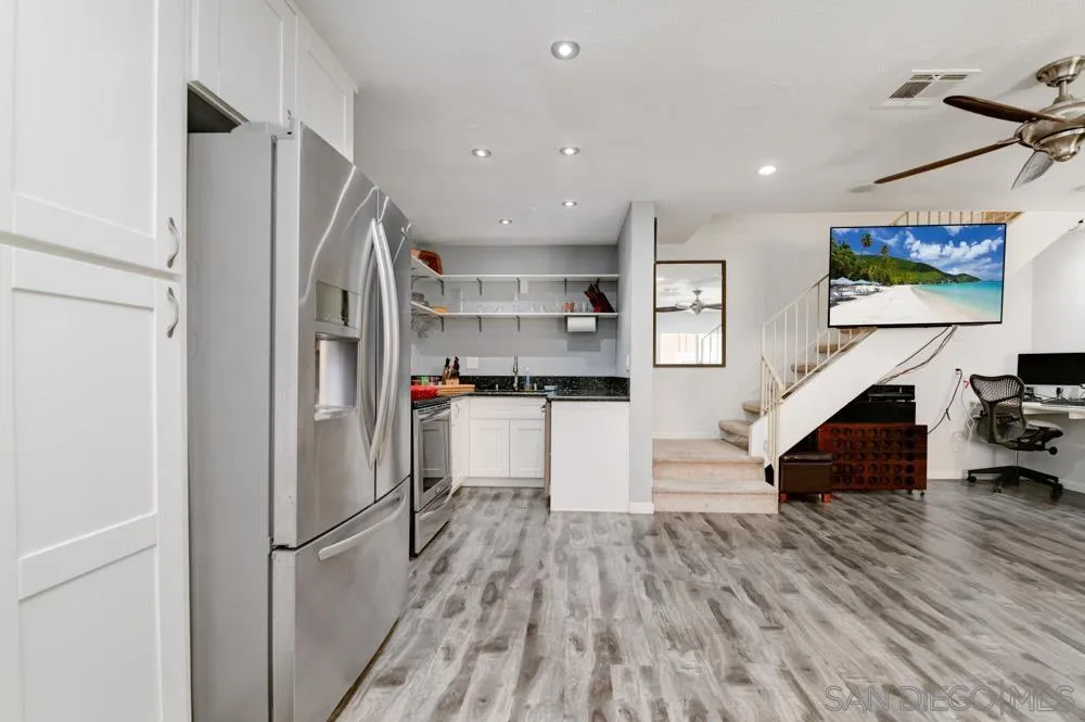 10423 Caminito Rimini San Diego, CA 92129 - Photo 11 of 25 a kitchen view with stainless steel appliances refrigerator stove and wooden floor