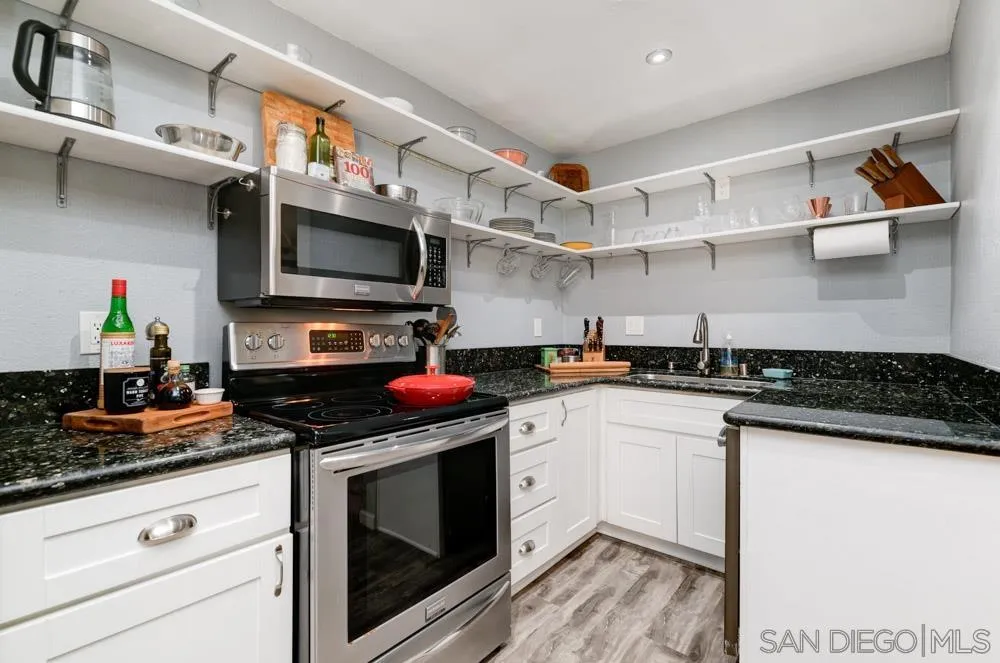 10423 Caminito Rimini San Diego, CA 92129 - Photo 13 of 25 a kitchen with stainless steel appliances a stove a microwave and cabinets