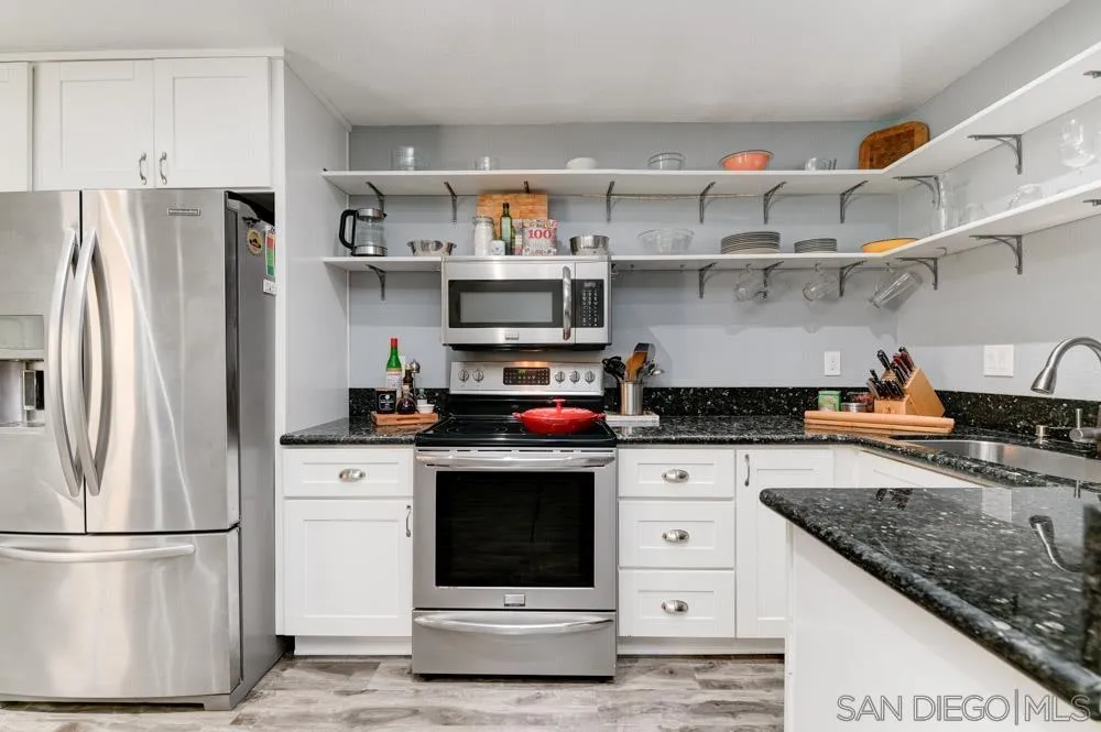 10423 Caminito Rimini San Diego, CA 92129 - Photo 14 of 25 a kitchen with cabinets and stainless steel appliances