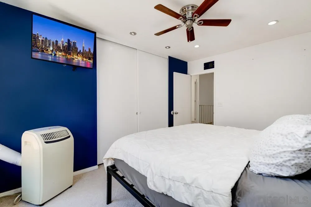 10423 Caminito Rimini San Diego, CA 92129 - Photo 20 of 25 a bedroom with a bed and a chandelier