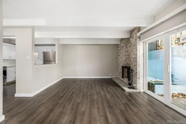 a view of empty room with wooden floor and fireplace