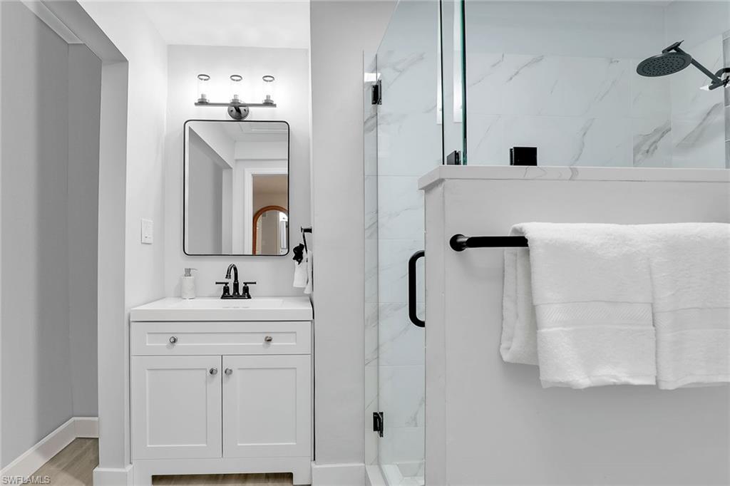 2780 Weeks Avenue Naples, FL 34112 - Photo 9 of 34 a bathroom with a double vanity sink a mirror and shower
