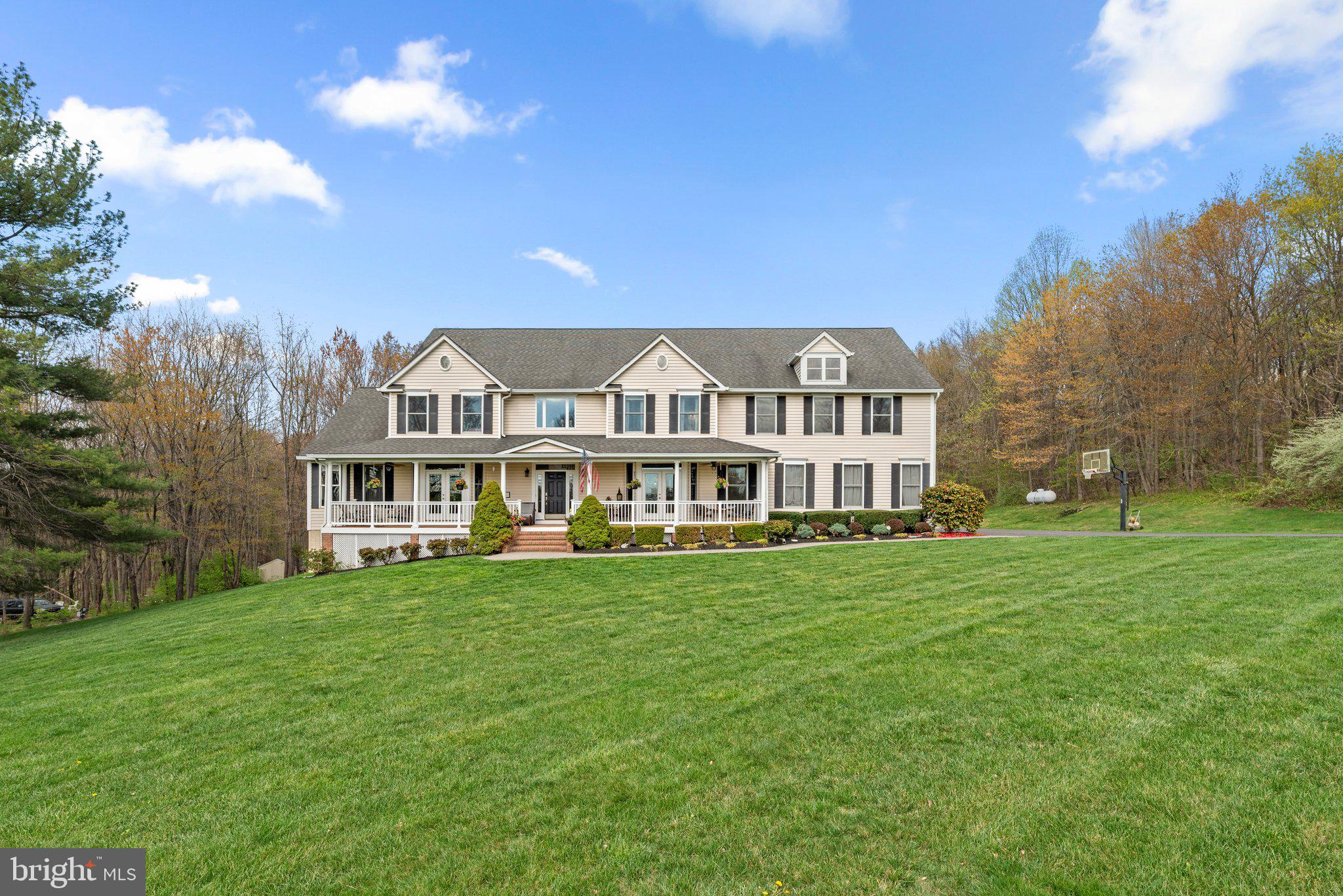 a view of a house with a big yard and large trees