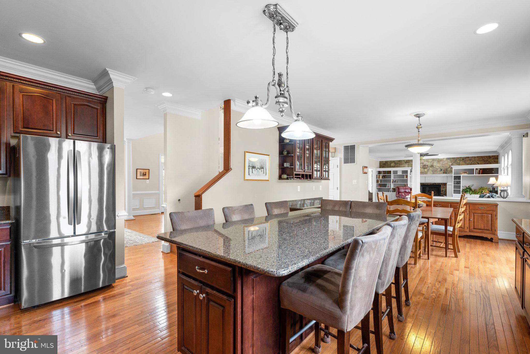 10855 Bethesda Church Road Damascus, MD 20872 - Photo 18 of 92 a kitchen with granite countertop a table chairs stainless steel appliances and wooden floor