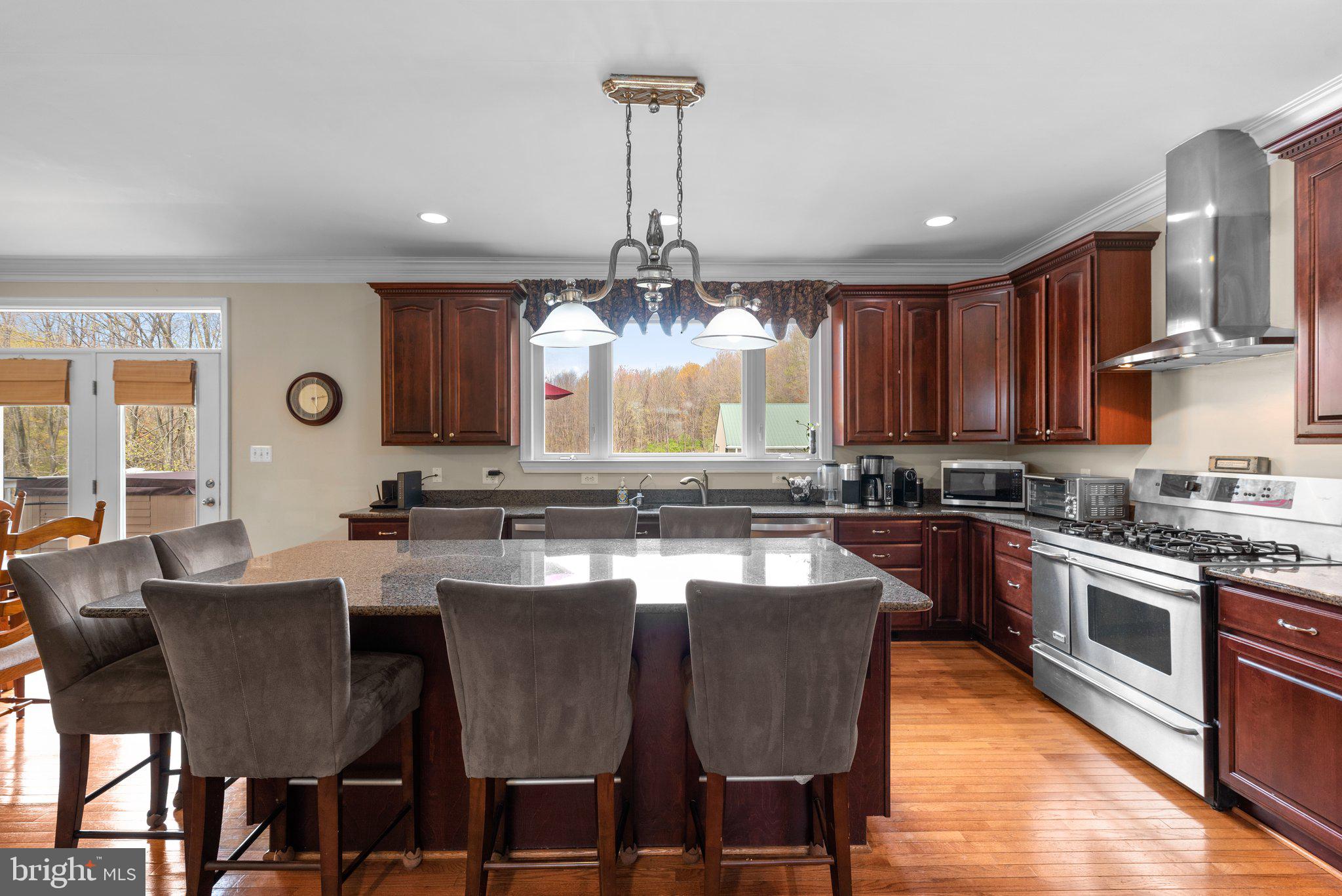 10855 Bethesda Church Road Damascus, MD 20872 - Photo 20 of 92 a kitchen with stainless steel appliances granite countertop a stove a sink dishwasher a dining table and chairs with wooden floor