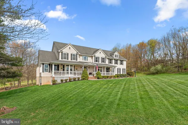 a view of a house next to a big yard with large trees