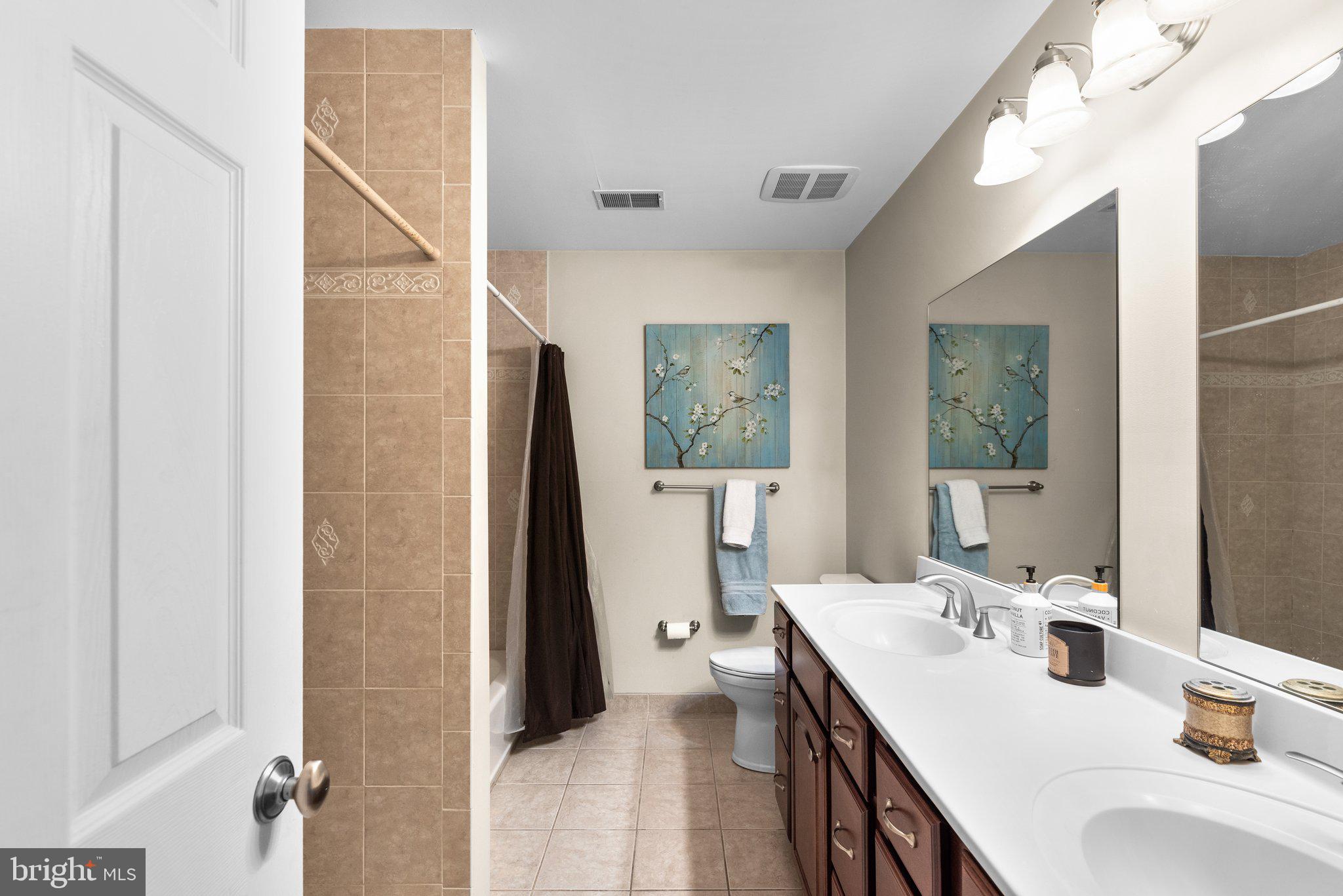 10855 Bethesda Church Road Damascus, MD 20872 - Photo 37 of 92 a en suite bathroom with a double vanity sink a mirror and a shower