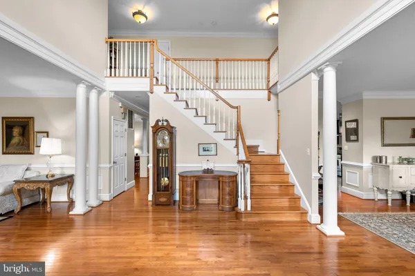 a dining room with wooden floor a chandelier a wooden table and chairs